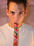skinny-boy-with-playful-eyes-alex-dark-strips-nude-while-playfully-licking-big-lollipops