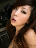 Clothed japanese model poses in sand on the beach and indoors on a bed