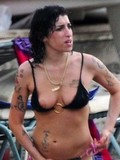 Topless Amy Winehouse showing her nice tits and multiple tattoos on the beach