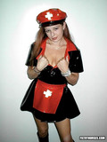 Filthy nurse in fetish uniform made of latex shows her heavy jugs and shaved cunt