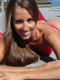 Sexy temptress with hairy arms poses in red bikini and shows her slim body