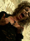 Screaming horror babe in leather boots and gloves shows her blood covered body