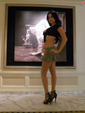 sexy-legged-brunette-in-short-grey-skirt-and-black-top-poses-in-high-heels