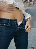 Skinny playful girl in very tight jeans flashes her white thong panties in public place