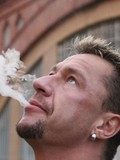middle-aged-bodybuilder-in-skin-tight-t-shirt-drives-a-car-and-smokes-a-cigarette