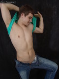 Young guy takes off his tight jeans and exposes his firm bare ass in the semi-dark