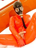 Asian tranny in black gas mask and orange latex suit shows her cock and anus