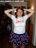 Redhead amateur girl in blue skirt and with no panties bends over to show her red spanked ass
