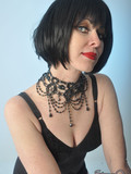 Middle aged woman with black hair poses in sexy stockings and smokes a cigarette