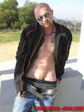Shaved headed transsexual man with cigar shows his amazing pussy in the open air