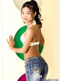 Slender asian girl in beautiful white lingerie pulls down her blue jeans