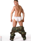 Guy with short fair hair poses in military style clothes and gets totally nude