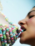 Curly haired brunette hungrily licks her girlfriend??s pussy over her funny candy thong